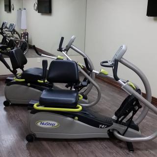 Two exercise bikes in a gym setting with mirrored walls.