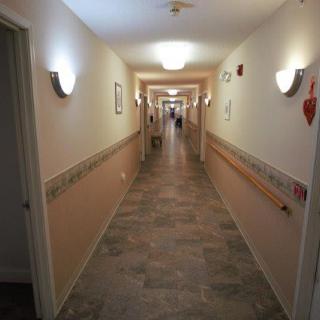 A well-lit indoor hallway with a tiled floor and handrails.