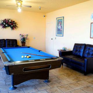 A cozy indoor space featuring a blue pool table and comfortable seating.
