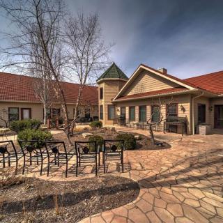 A serene courtyard featuring a stone path, seating area, and elegant architecture.
