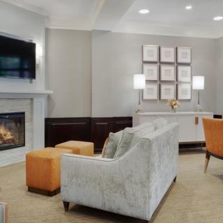 A modern living room with a fireplace, television, and orange accents.