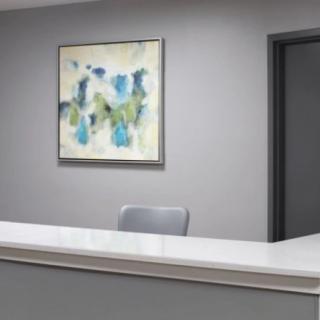 A minimalist office reception area with a modern artwork on the wall.