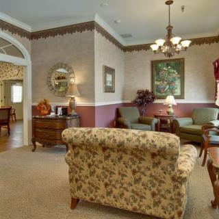 A traditionally decorated living room with floral-patterned furniture and warm lighting.