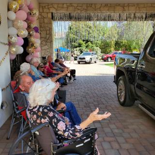 A serene gathering of seniors enjoying the outdoors, adorned with festive balloons.