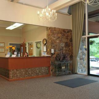 A spacious lobby area with a reception desk and chandelier.