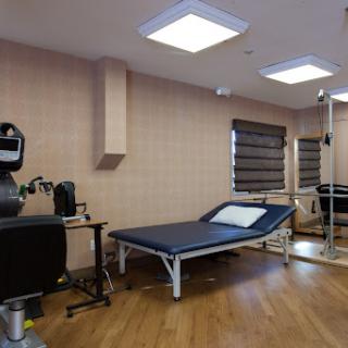 A modern therapy room equipped with an examination table and medical devices.