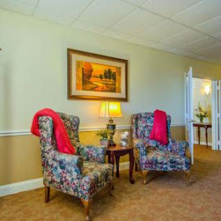 A cozy living room with floral armchairs and warm lighting.