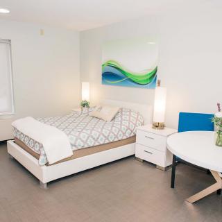 A modern, minimalist bedroom featuring a bed with geometric bedding and contemporary decor.