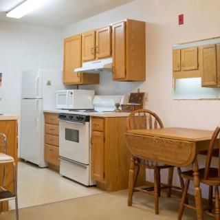 A cozy kitchen with wooden cabinets and a small dining area featuring a table and chairs.