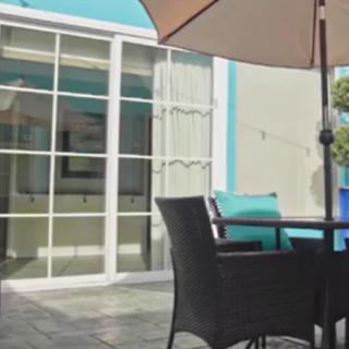 Outdoor patio seating area with an umbrella and modern furniture.