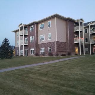 A view of a residential apartment complex, showcasing modern architecture amidst a green landscape.