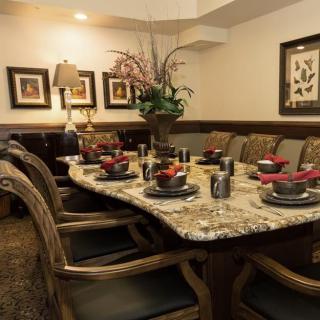 A beautifully set dining table in an elegant dining room, featuring a decorative centerpiece and art on the walls.