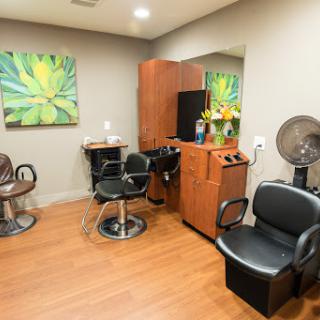 A well-designed salon space featuring comfortable chairs, stylish decor, and ample lighting for hair styling services.