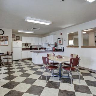 A retro-style kitchen with a checkered floor and vintage dining furniture.