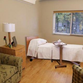 A cozy room with a single bed, window, and comfortable seating area.
