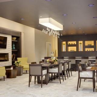 Modern dining area with elegant chandeliers and contemporary seating.
