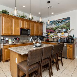 A stylish modern kitchen featuring wooden cabinets, granite countertops, and a welcoming seating area.