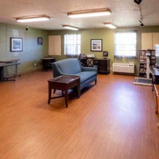 A spacious room with a sofa and table, featuring hardwood floors and decorative elements.