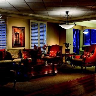 A cozy and warmly lit living room featuring comfortable seating and elegant decor.