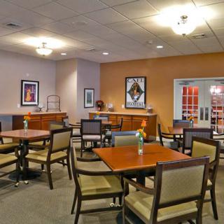 A modern and well-lit dining area featuring neatly arranged tables and chairs with contemporary decor.