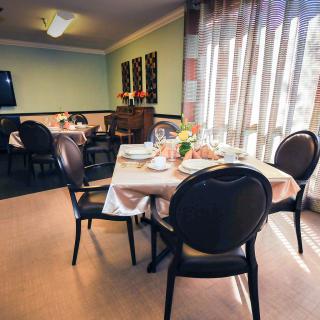 A cozy dining room with elegantly set tables and soft lighting.