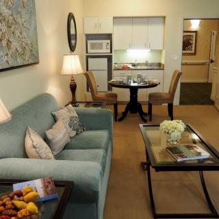 Cozy living room with a sofa, table, and kitchenette.