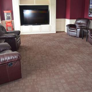 A cozy home theater with leather recliners and a large TV.