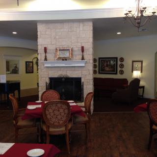 A cozy dining area featuring a central fireplace with elegant seating arrangements.