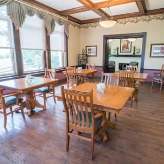 A well-lit dining room featuring wooden tables and chairs, creating a warm and inviting atmosphere.
