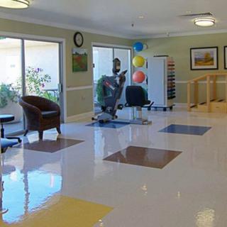 A bright and spacious lobby area with colorful floor tiles, chairs, and balloons by the window.