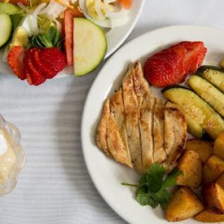 A delicious and healthy meal featuring grilled chicken with assorted vegetables and a fresh salad.