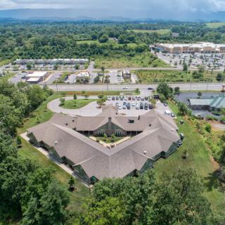 Aerial view of a hexagonal building surrounded by lush greenery and urban development.
