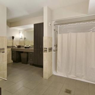 A modern bathroom with a double sink and a curtained shower area.