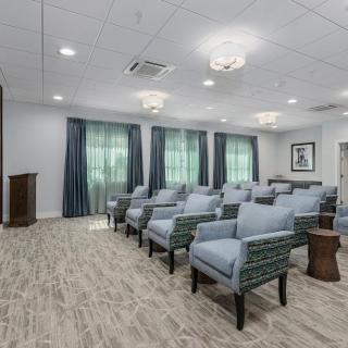 A modern conference room with neatly arranged seating and a podium at the front.