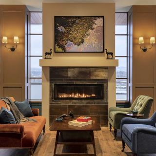 A cozy living room features a warm fireplace, comfortable seating, and tasteful decor.