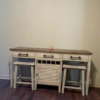 A rustic console table with stools in a vintage style.