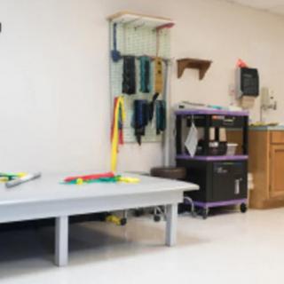 A physical therapy room equipped with various exercise and rehabilitation tools.