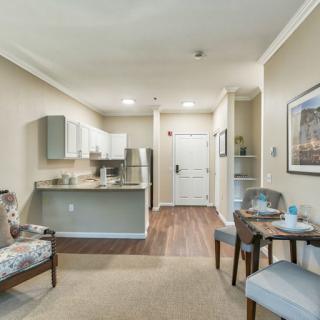 A modern apartment interior featuring a compact kitchen, a cozy living area, and a small dining space.