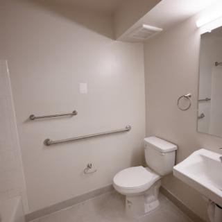 A modern bathroom designed with accessibility features including grab bars for safety.