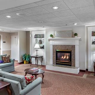 A cozy living room featuring a fireplace, comfortable sofas, and elegant lighting.