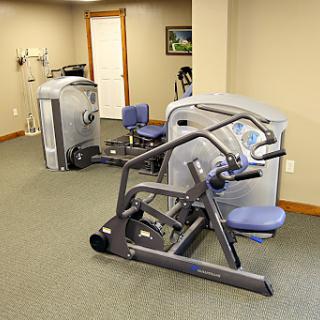 A well-equipped home gym featuring various exercise machines for strength training.