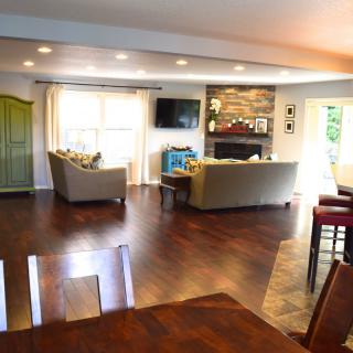 Spacious modern living room with hardwood floors, cozy couches, and a fireplace.