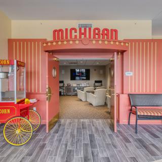 A cozy theater entrance with a popcorn machine and seating area.