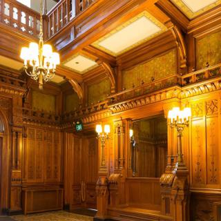 An opulent interior with rich wood paneling and a classic chandelier.