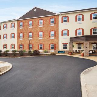 A multi-story hotel with a brick facade and a covered entrance accompanied by a roundabout driveway.