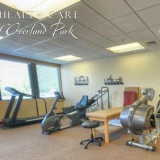 A well-equipped fitness room featuring exercise machines and a physiotherapy table.