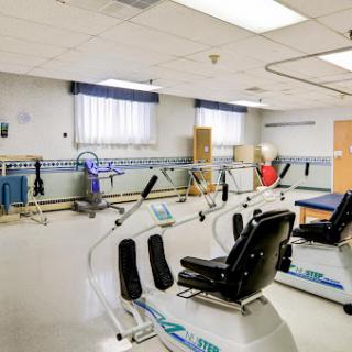 A spacious rehabilitation therapy room equipped with various fitness equipment for patient exercises.