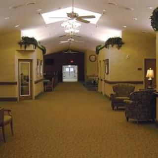 A well-lit lobby hallway with comfortable seating and decorative greenery.