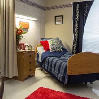 A cozy bedroom with a neatly made bed and decorative elements.