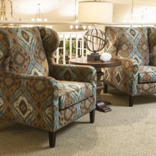 A cozy sitting area featuring two patterned armchairs and a small round table with decorative items.